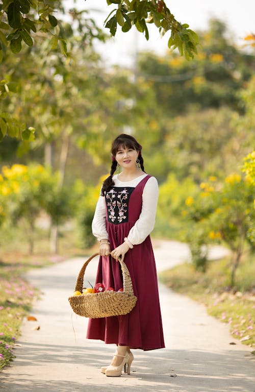 Free Woman in Fairytale Dress Holding Basket Stock Photo