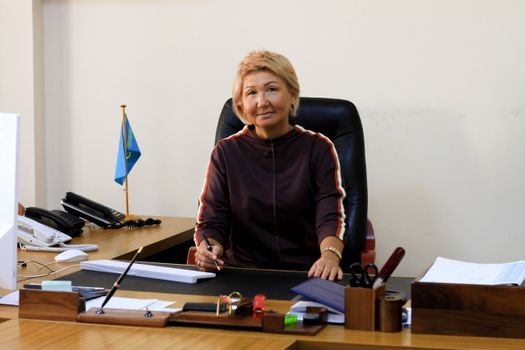 Businesswoman with short hair working at her desk in a contemporary office setting.