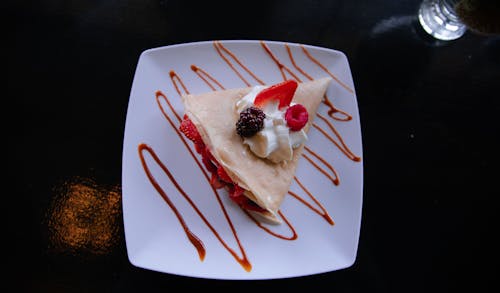 Crepe With Cream and Fresh Berries on a Ceramic Plate