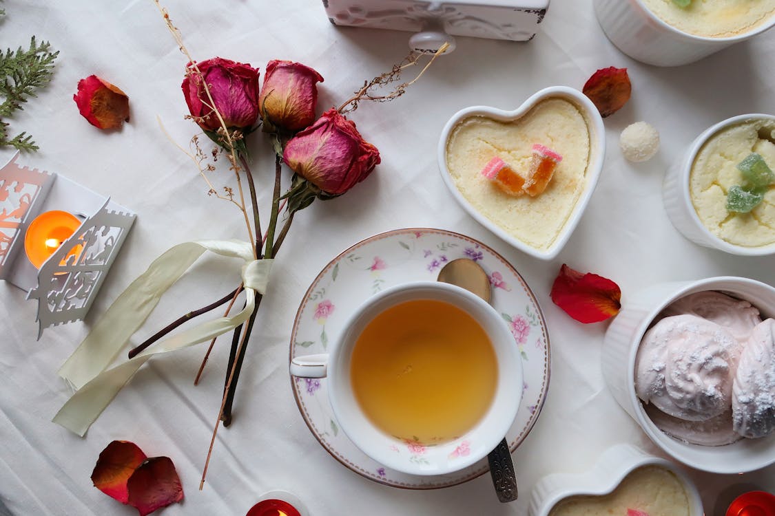 A Cup of Tea Beside Red Roses