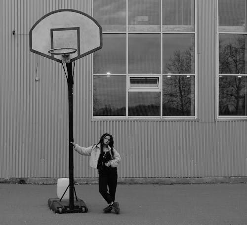 Free Grayscale Photo of Woman Standing Beside Basketball Hoop Stock Photo