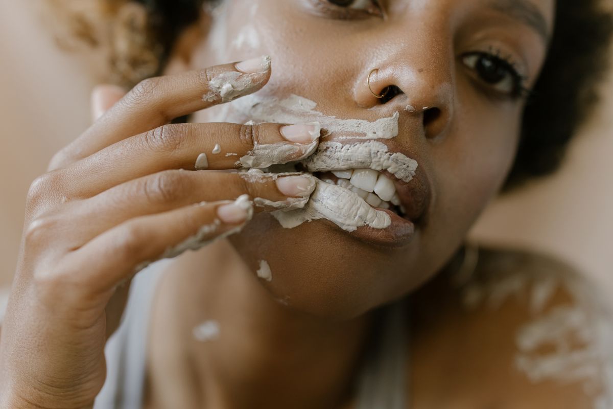 Mujer aplicando una mascarilla facial de arcilla