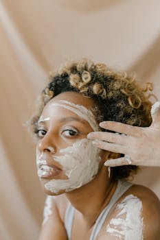Close-up portrait of a woman with a clay mask during a skincare routine in a studio.