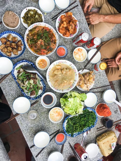 Free An overhead view of a traditional Vietnamese meal laid out with various colorful dishes and drinks. Stock Photo