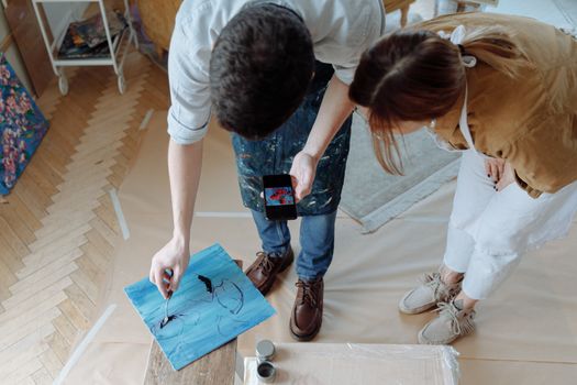 Art students painting together indoors, capturing creativity and learning in a studio setting.