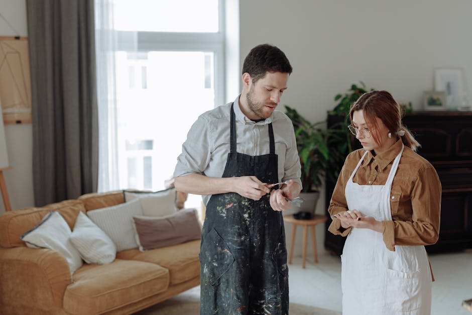 Splitwise vs Honeydue: Splitting Bills for Couples Man and woman in aprons discussing art in a bright, modern studio.