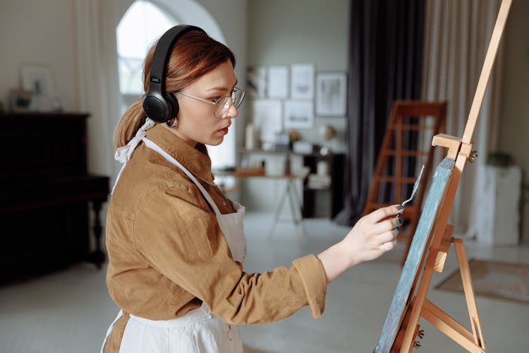 
A Woman Knife Painting While Listening To Music