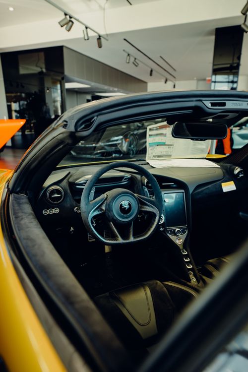Free Discover the sleek design of a luxury car interior featuring a high-tech dashboard in a showroom. Stock Photo