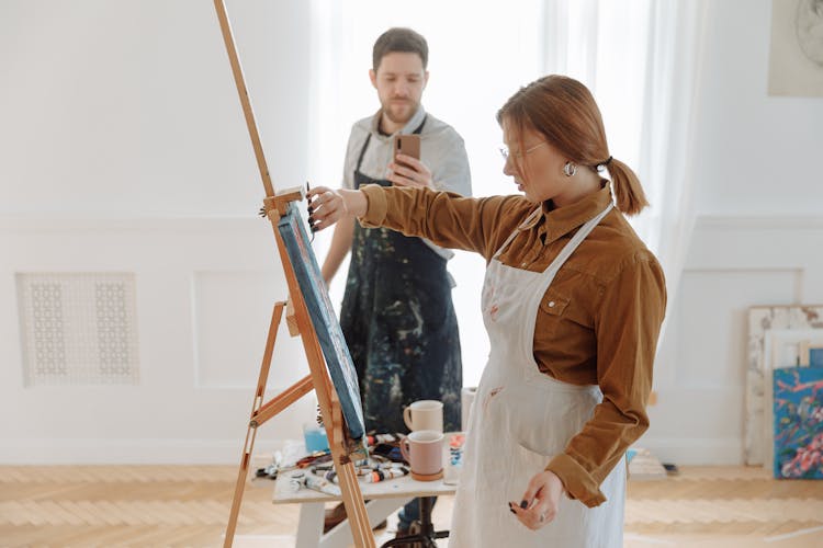 A Man Taking A Picture Of A Woman Knife Painting