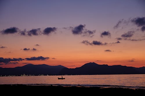 A Boat Sailing on the Sea During Sunset