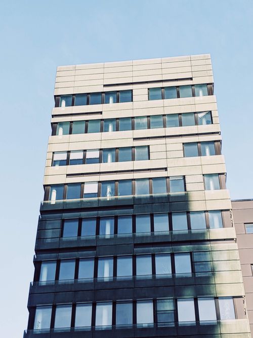 Free Contemporary skyscraper facade with glass windows in bright daylight. Stock Photo