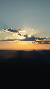 Stunning sunrise with dramatic sunrays over a serene mountain landscape.