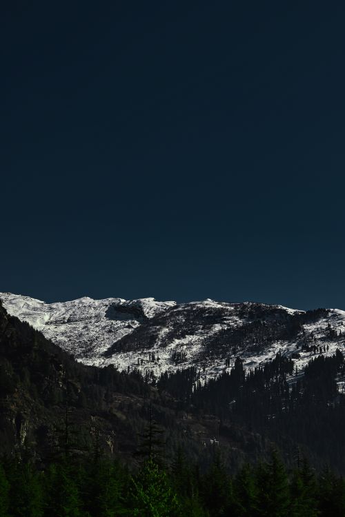 Free Capture of snow-capped mountains beneath a clear blue sky, offering a serene natural landscape. Stock Photo