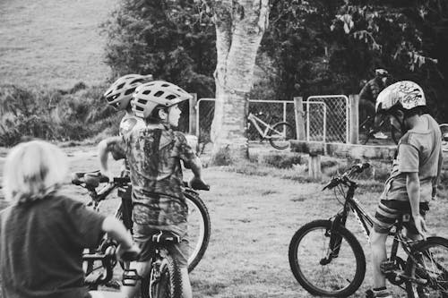 Fotografia Em Tons De Cinza De Crianças Andando De Bicicleta