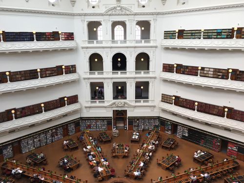 Free Beautiful multi-level library interior with study desks and bookshelves, fostering education and learning. Stock Photo