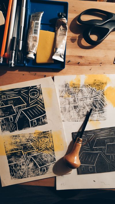 Lino printing tools and freshly carved blocks on a wooden table
