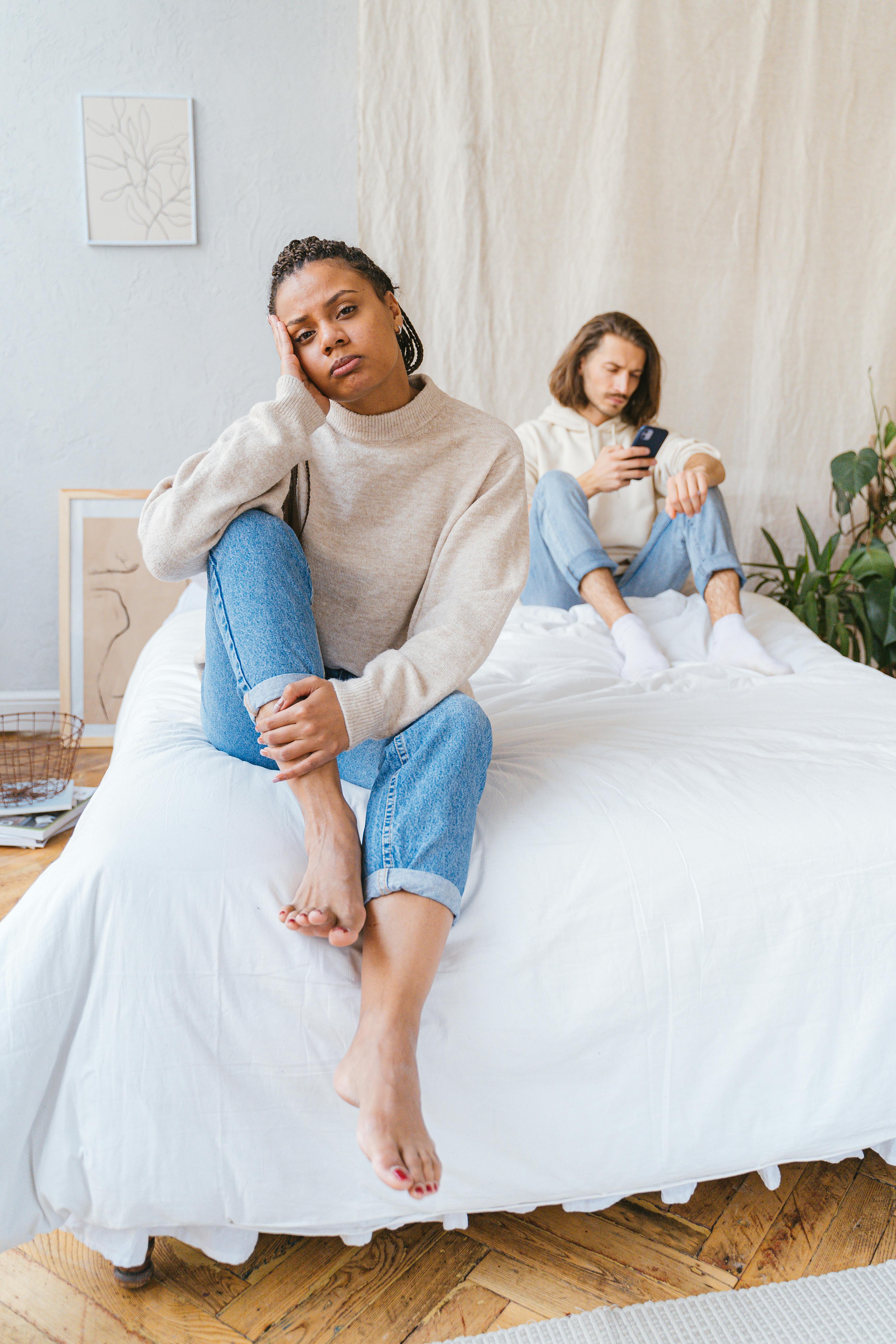 a woman crying while sitting on the bed