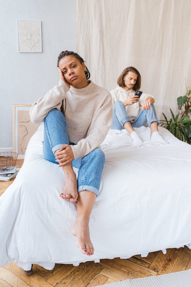 A Woman Crying While Sitting On The Bed