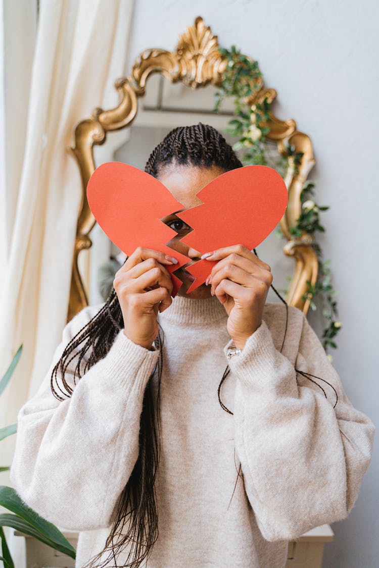 A Woman Holding A Broken Heart Made Of Paper