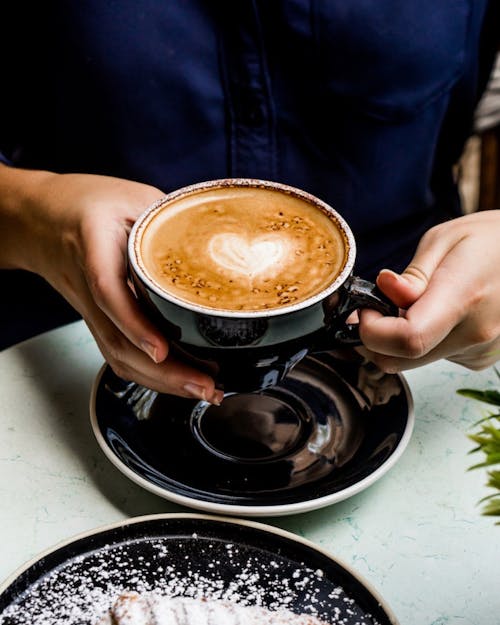Free A Person Holding a Cup of Coffee Stock Photo