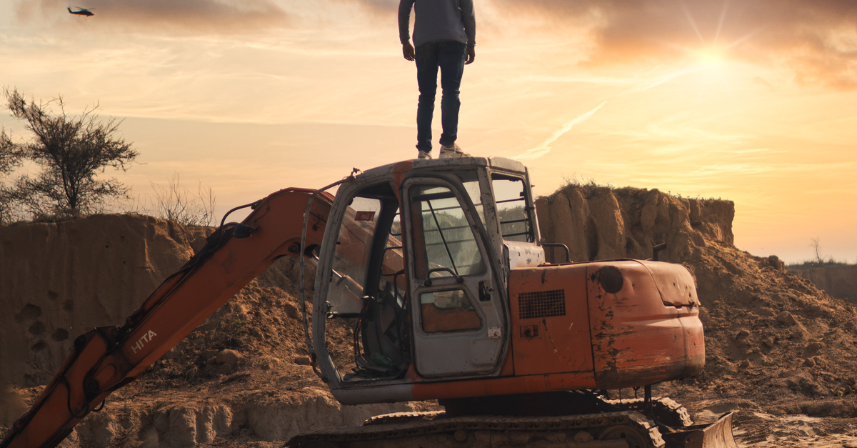 Man Using Backhoe Man Standing on a Backhoe · Free Stock Photo
