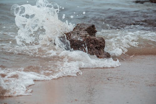 Ocean Waves Crashing on Brown Big Rock in the Seashore