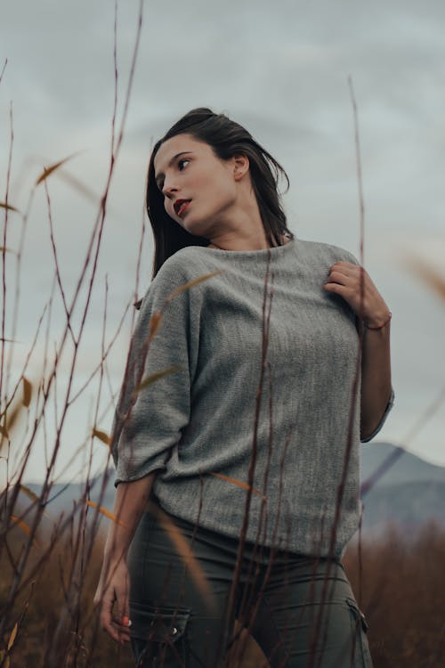 Woman in Gray Shirt Standing on Grass Field