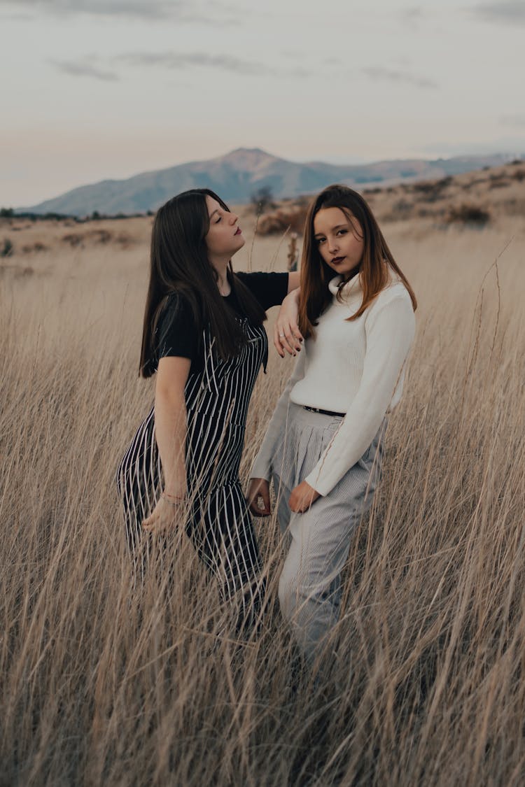 Beautiful Girls Standing On Brown Grass Field