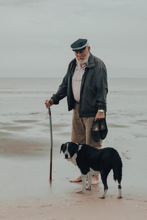Free Man Walking with His Dog in the Seashore Stock Photo