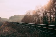 在白俄罗斯，一条雾气缭绕的铁路轨道穿过秋日雾蒙蒙的森林，捕捉了宁静的自然与运输景象