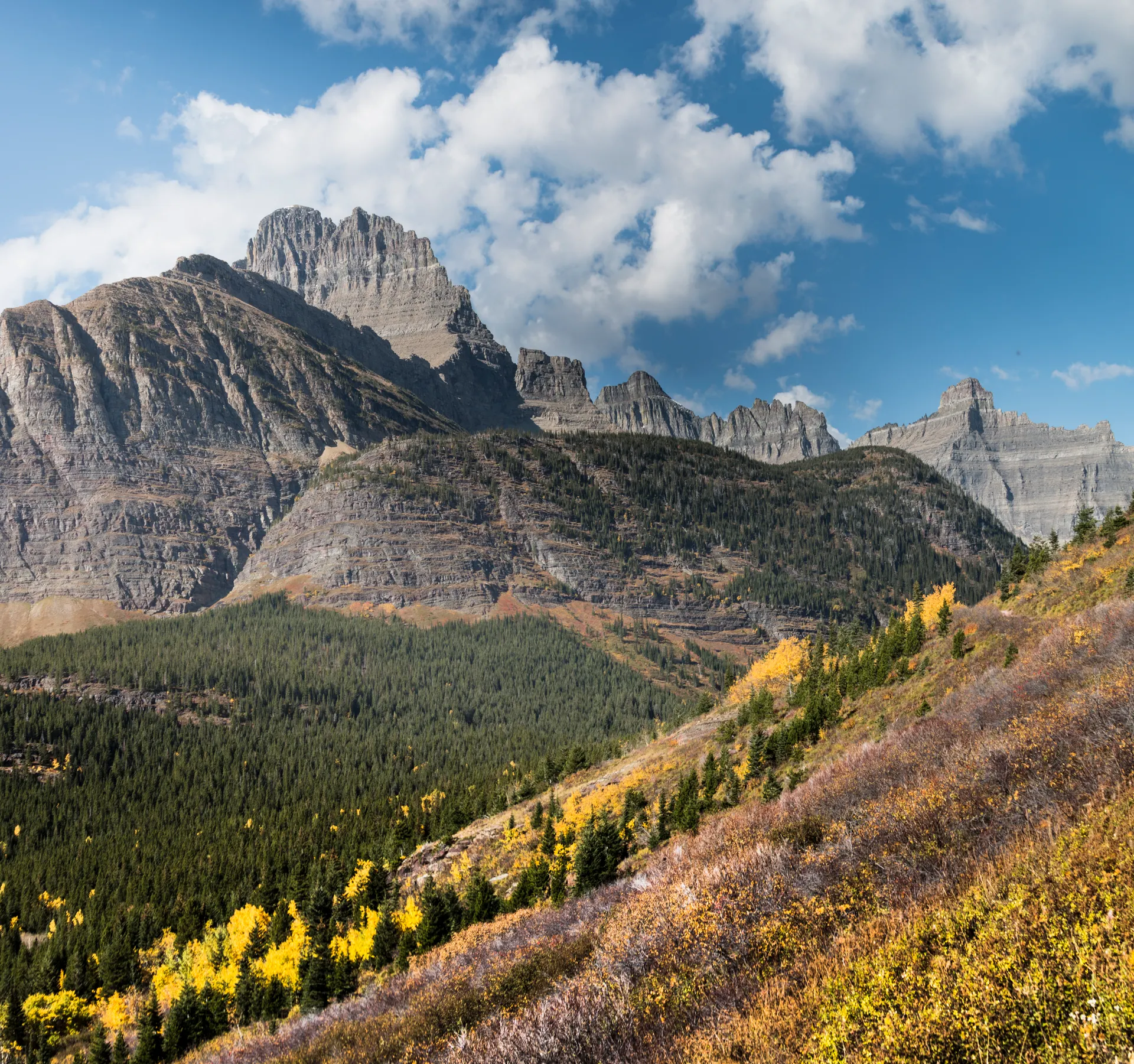 Autumn landscape of Glacier National Park with mountains, trees, and a vast sky. Autumn landscape of Glacier National Park with mountains, trees, and a vast sky.