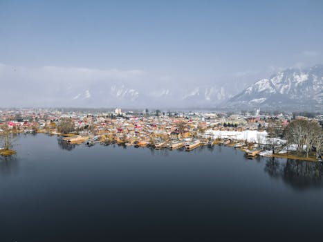 Stunning aerial view of Srinagar's Dal Lake with a backdrop of snowy mountains.