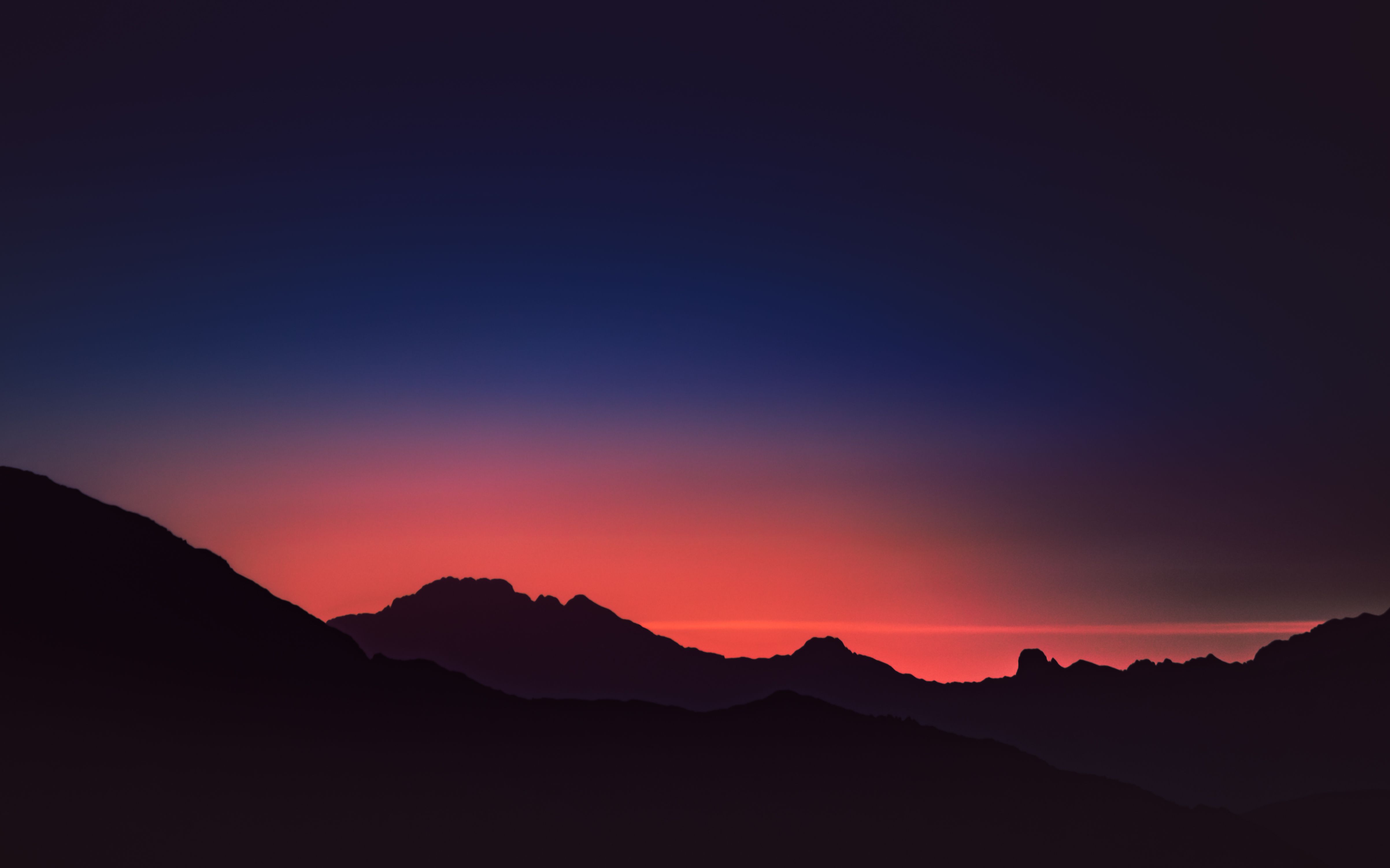 Breathtaking view of Swiss mountains silhouetted at twilight with vibrant colors in the sky.