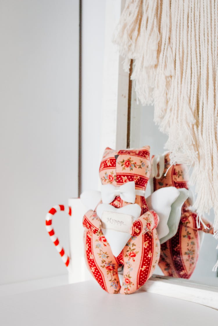 Soft Toy And Candy Cane Composed On Table Near Mirror