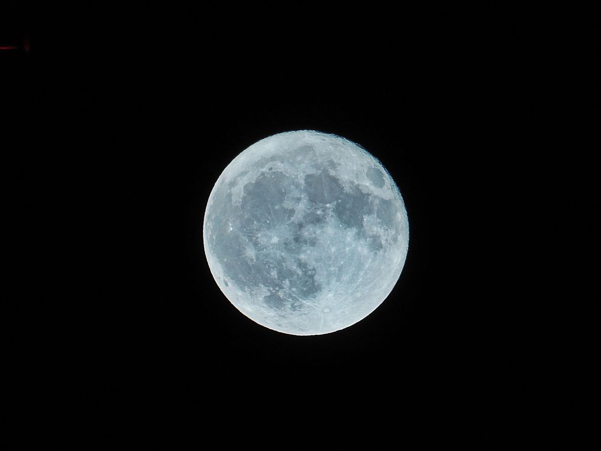 Permukaan Bulan purnama terlihat terang pada langit malam