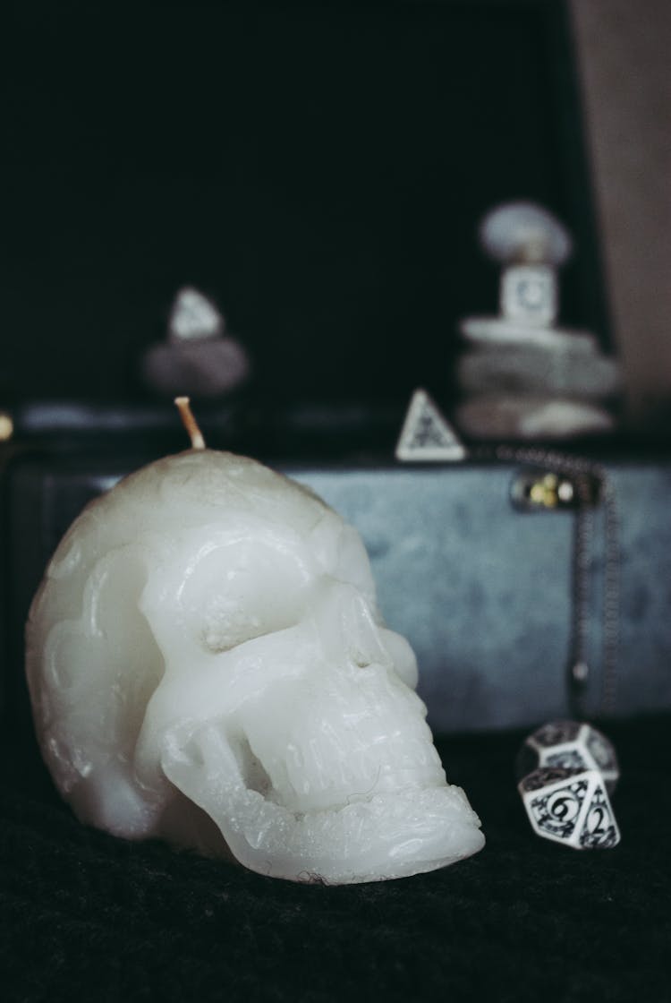 Skull Shaped Candle And Various Occult Items Composed On Table