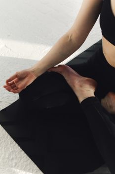 A woman practicing yoga meditation indoors on a mat, promoting serenity and mindfulness.