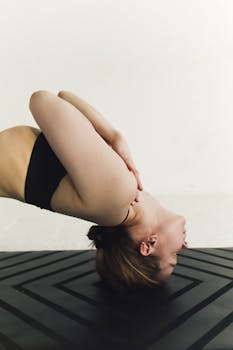 A woman performing a backbend yoga pose with eyes closed, showcasing flexibility and balance.