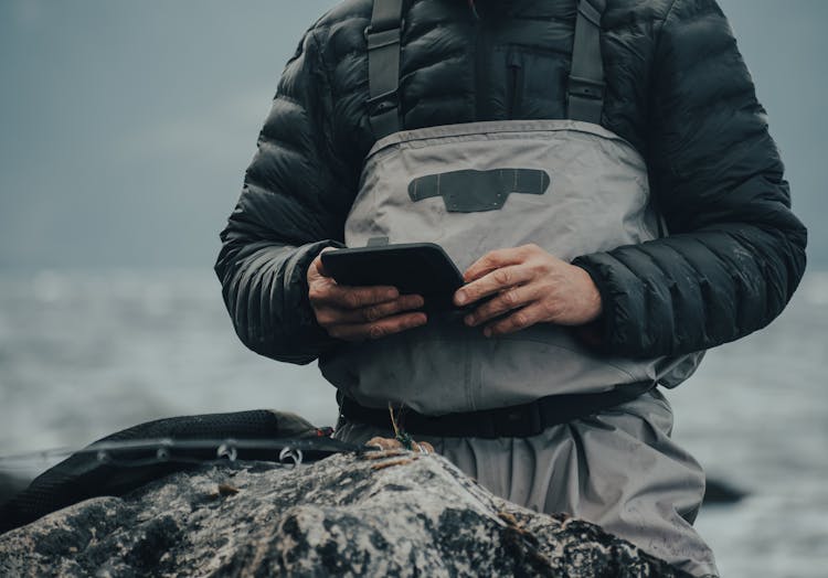 A Person In Black Jacket Holding Black Object