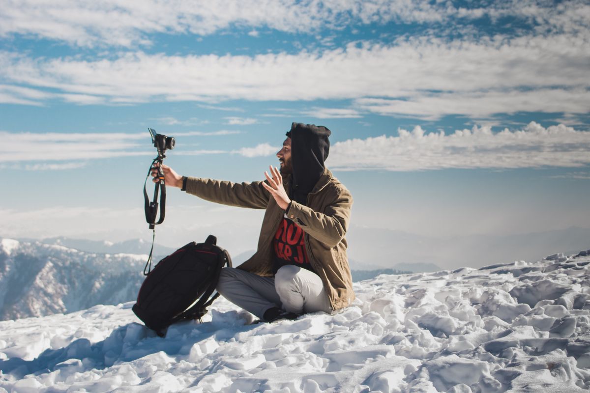 Vlogger care se filmeaza singur, cu zapada si nori sub el