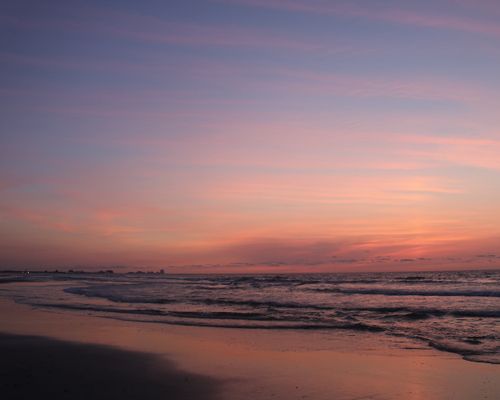 Free Capture the tranquility of a serene sunrise over gentle ocean waves on a peaceful beach. Stock Photo