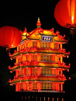 Brightly lit traditional Chinese pagoda with red lanterns celebrating Lunar New Year at night.