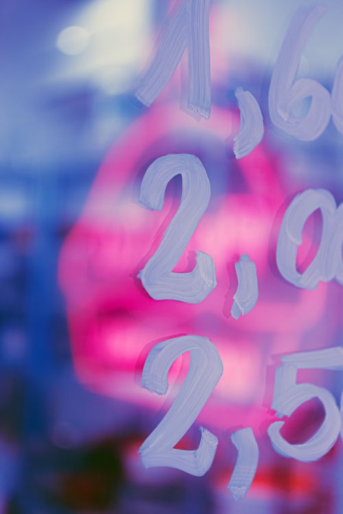 Free Close-up abstract image of numbers painted on glass with vibrant pink and blue hues. Stock Photo