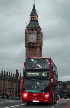 A classic red double-decker bus passes by Big Ben in the heart of London.