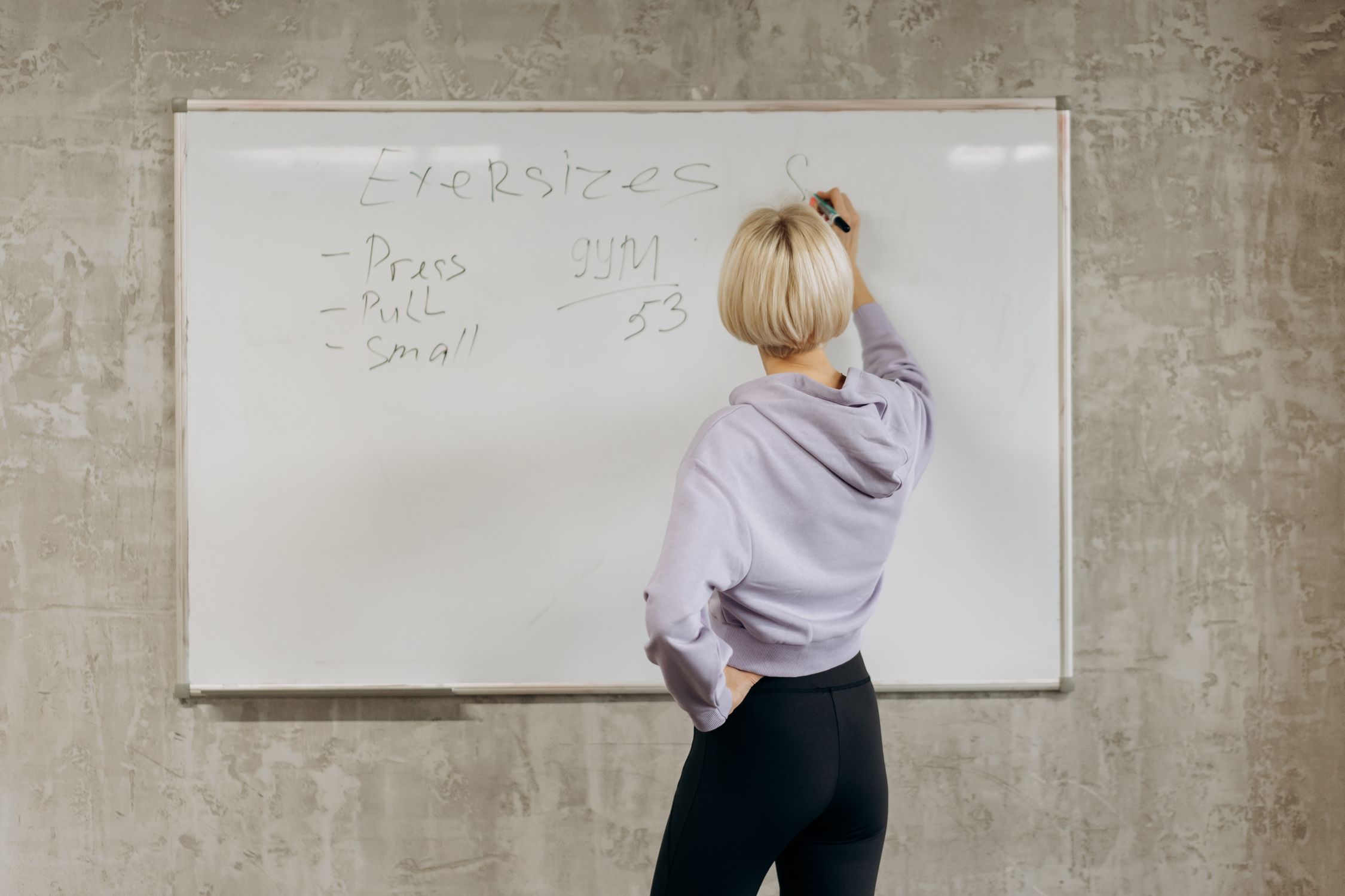 Mulher se preparando para o exercício físico em uma academia, demonstrando a disciplina estruturante na prática