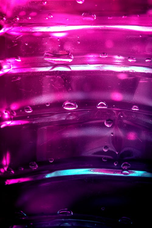Water Drops on Illuminated Pink Glass Surface
