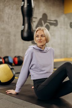 Adult woman taking a break during her workout in a modern gym setting.