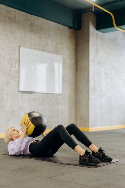 Woman Lying On A Mat With A Ball