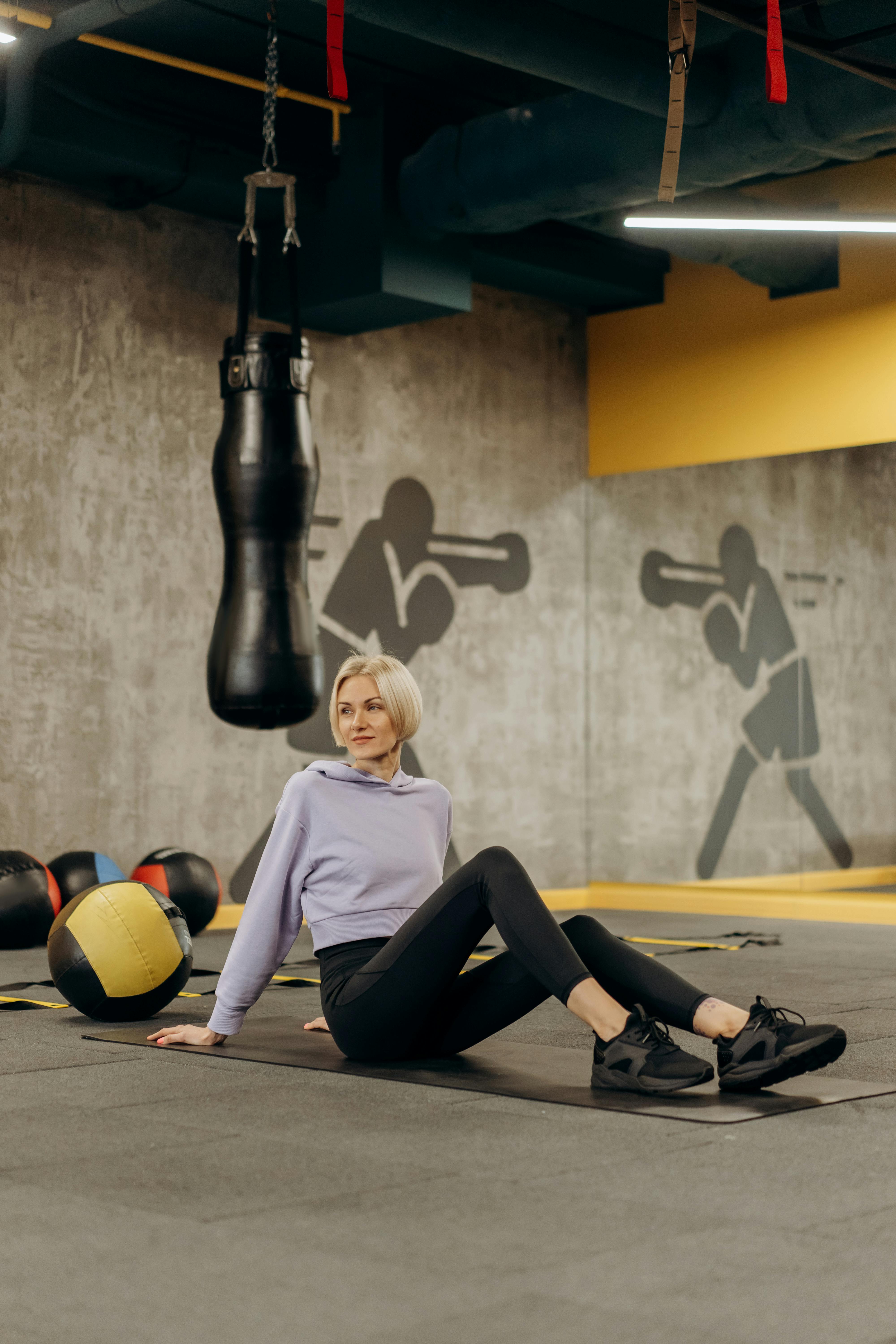 woman lying on a mat beside an exercise ball