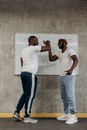 Men in White Crew Neck T-shirt and Blue Denim Jeans doing a High-Five